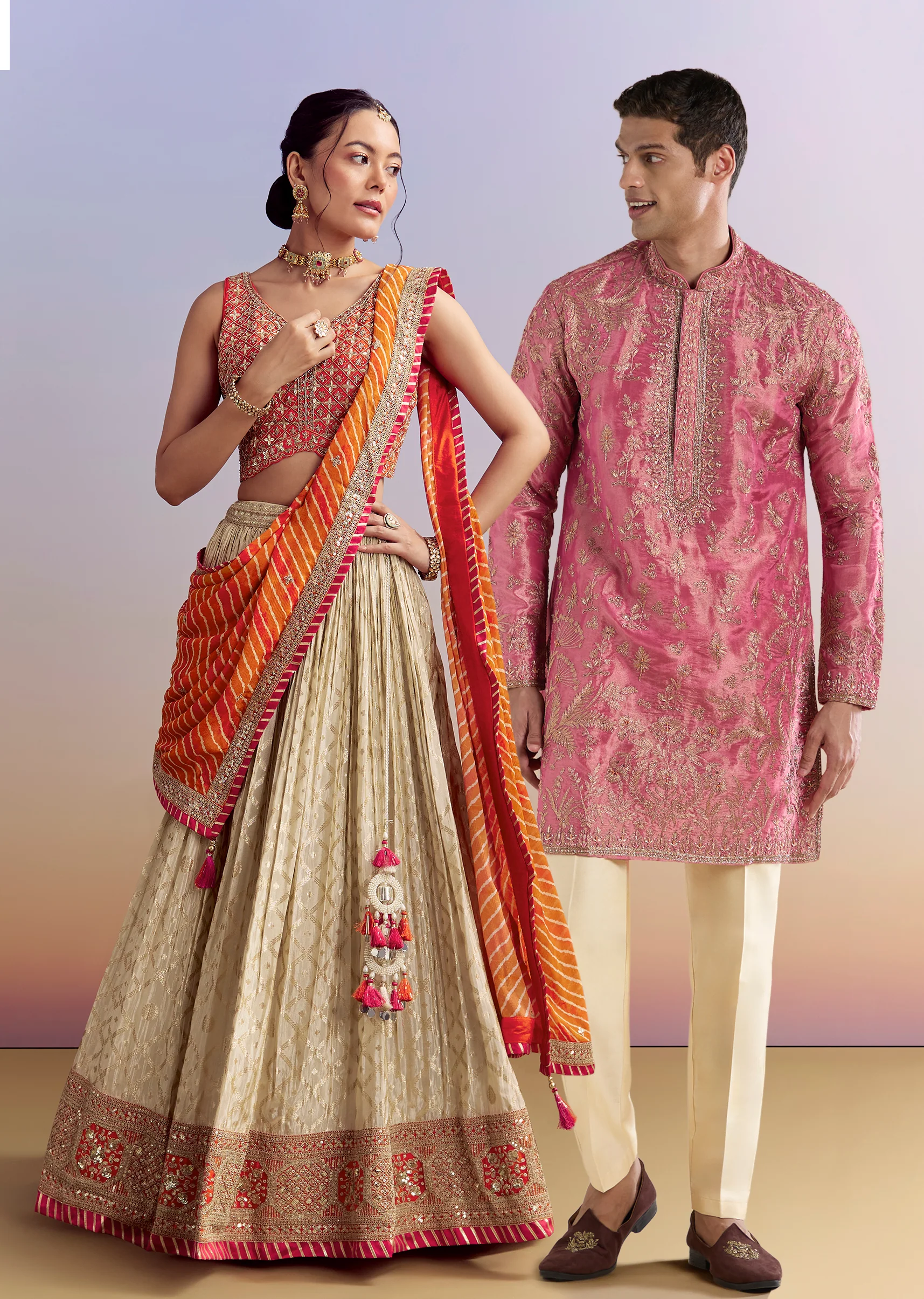 Festive Wedding Couple Set – Orange Brocade Bridesmaid Lehenga with Leheriya Dupatta for Her And Pink Embellished Tissue Kurta Set for Him